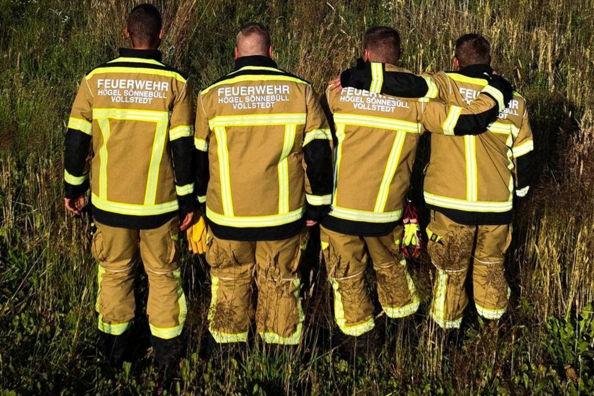 Auch auf der Kleidung ist der Zusammenschluss deutlich zu erkennen. Vier Feuerwehrleute zeigen ihren Rücken und die Aufschrift auf ihren Jacken - dort steht Högel, Sönnebüll, Vollstedt