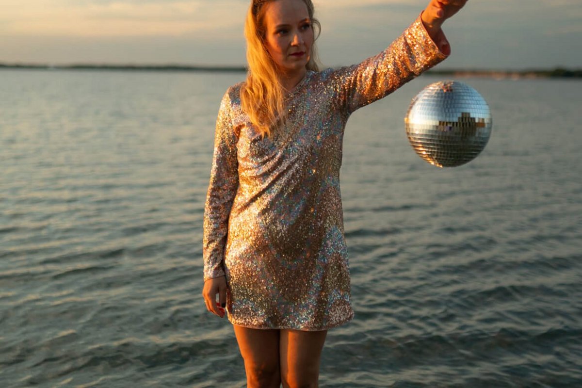 Sara Weiß tritt am 25. Juni im Amsinck-Haus auf. Foto: Anna-Sophie Rönsch Eine Frau steht im Wasser und hält eine silberne Kugel mit einer Hand