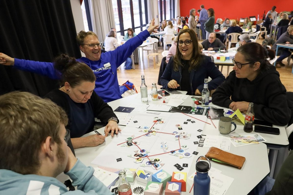 In verschiedenen Workshops entstanden wichtige Impulse für eine neue Bildungslandschaft im Mittleren Nordfriesland. Foto: Baupiloten Eine Gruppe Frauen und Männer sitzt an einem Tisch