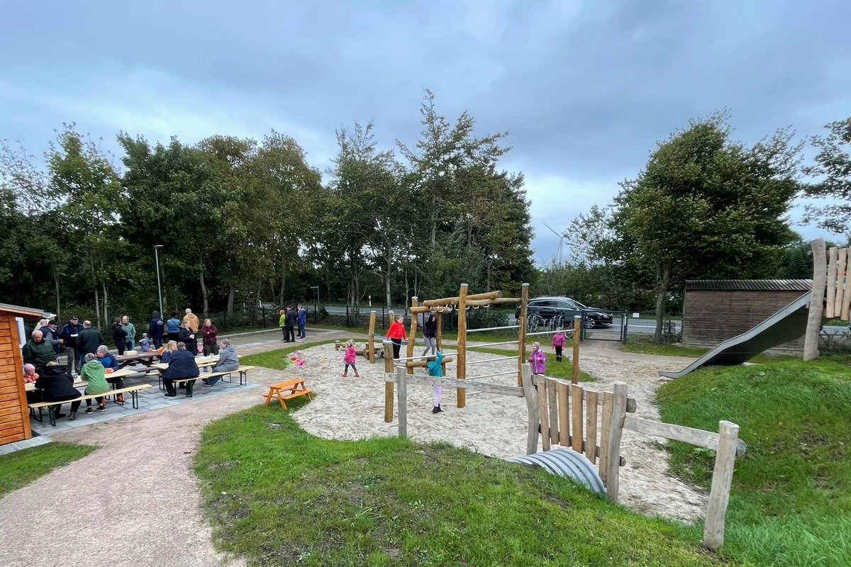 Der neue Dorfplatz in Kolkerheide mit Spielgeräten, Boulebahn, Sitzgelegenheiten und Schutzhütte. Ein Spielplatz mit Klettergeräten und viel Sand am Boden