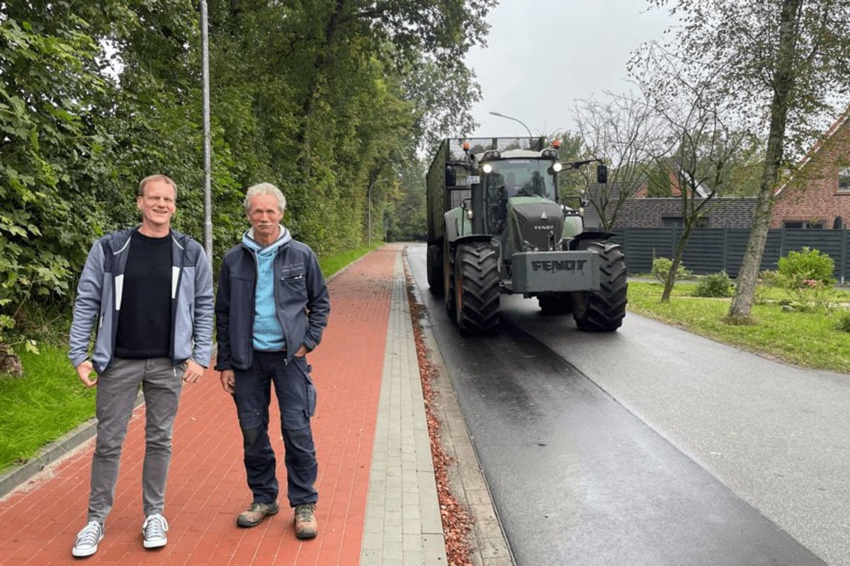 Joldelunds Bürgermeister Melf Hansen (links) und Schulhausmeister Günter Christiansen sind erleichtert, dass der neue Gehweg sich positiv auf das Parkverhalten vor der Schule auswirkt. Foto: Felix Middendorf Zwei Männer auf einem Bürgersteig