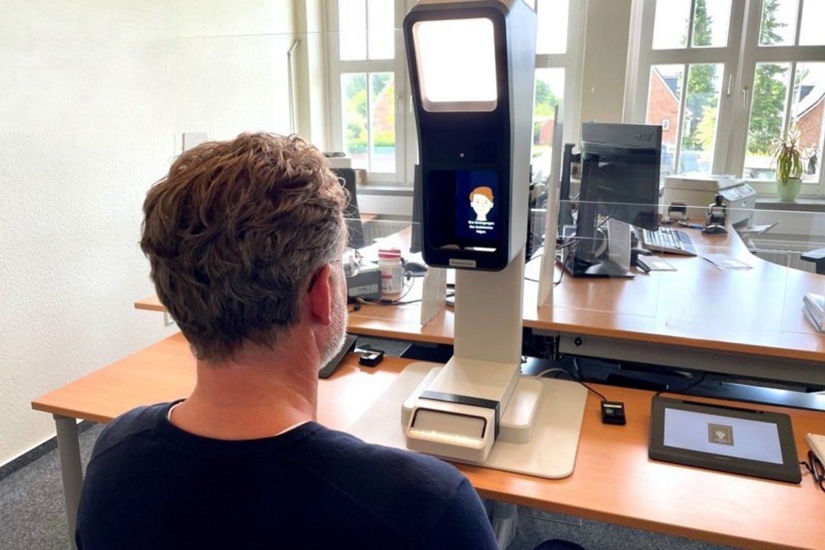 Die „Fotobox“ im Einwohnermeldeamt der Verwaltung in Bredstedt . ein Mann sitzt vor einem großen Fotoapparat